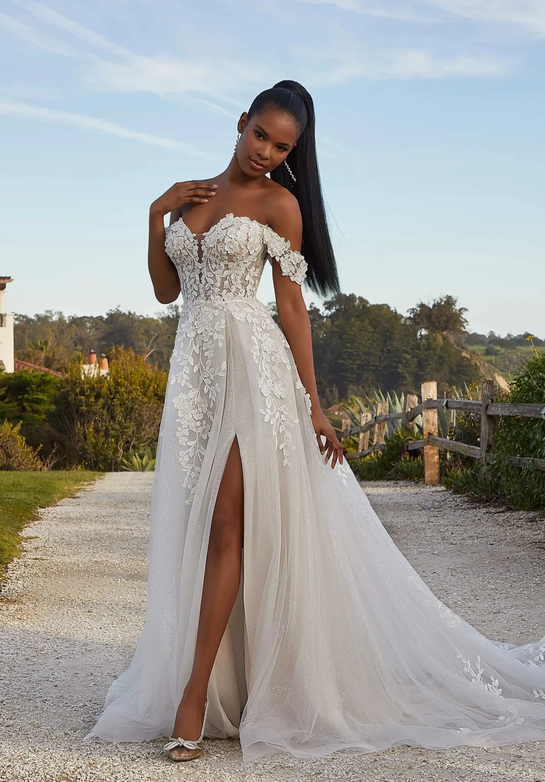 model is wearing an off the shoulder lace a-line bridal gown