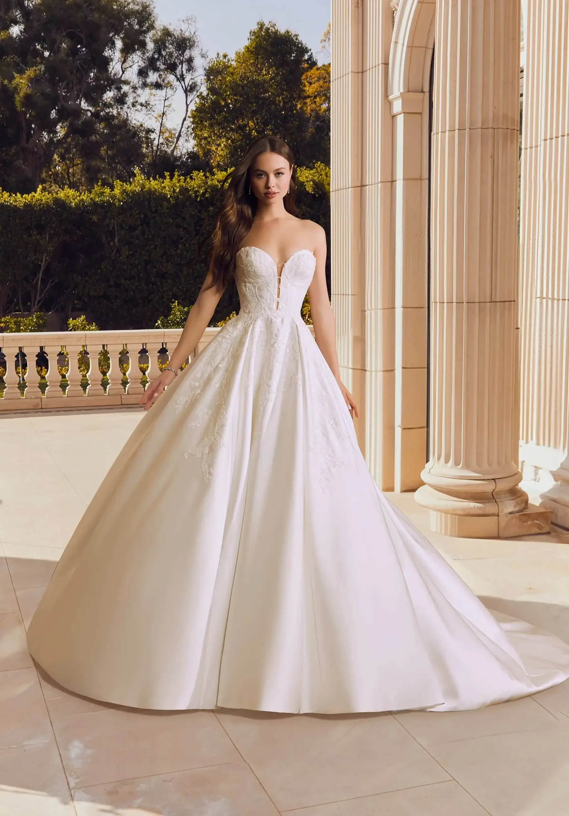 model is wearing a strapless ball gown wedding dress by morilee