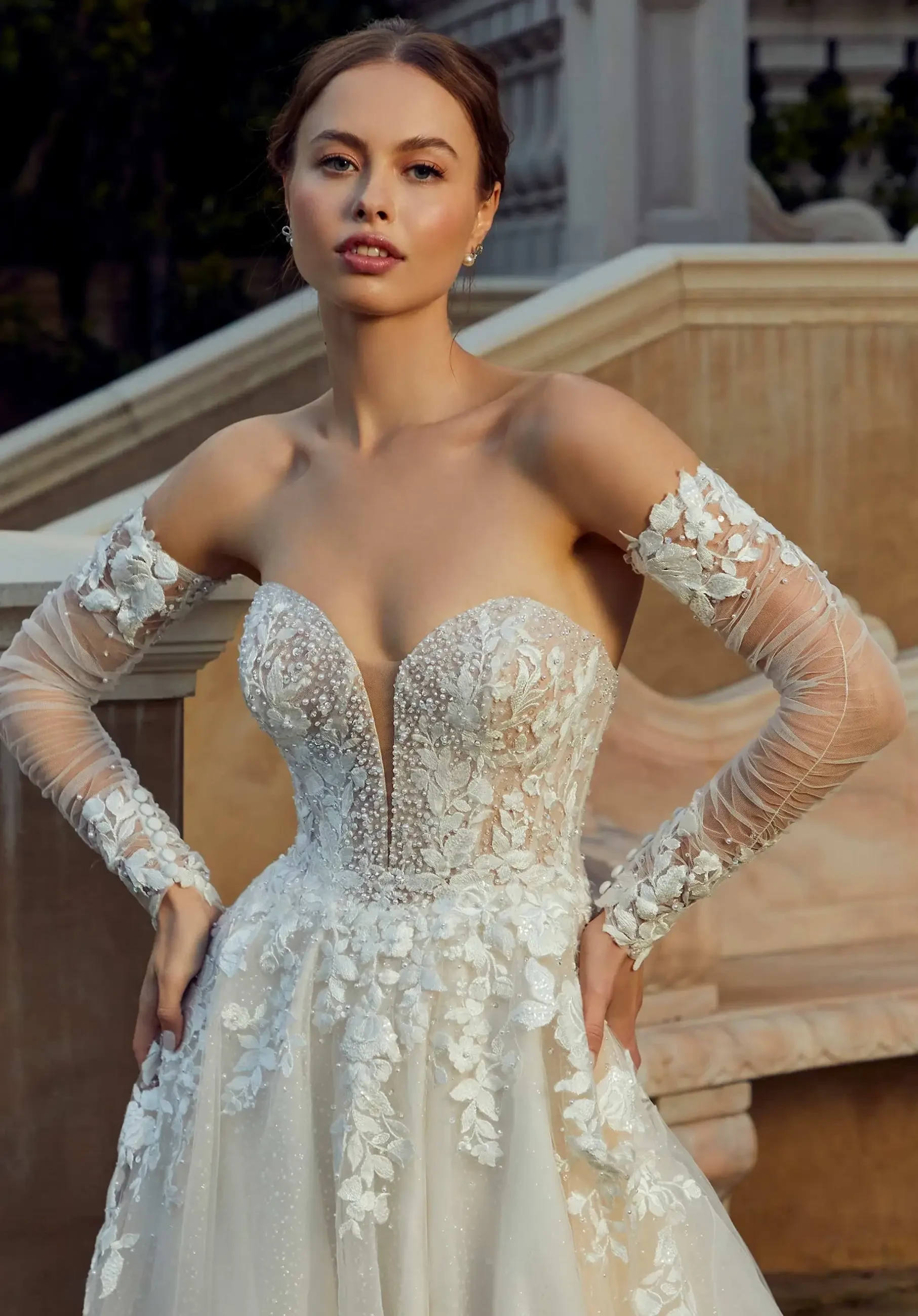 model is wearing a strapless a-line wedding dress with off the shoulder detachable sleeves