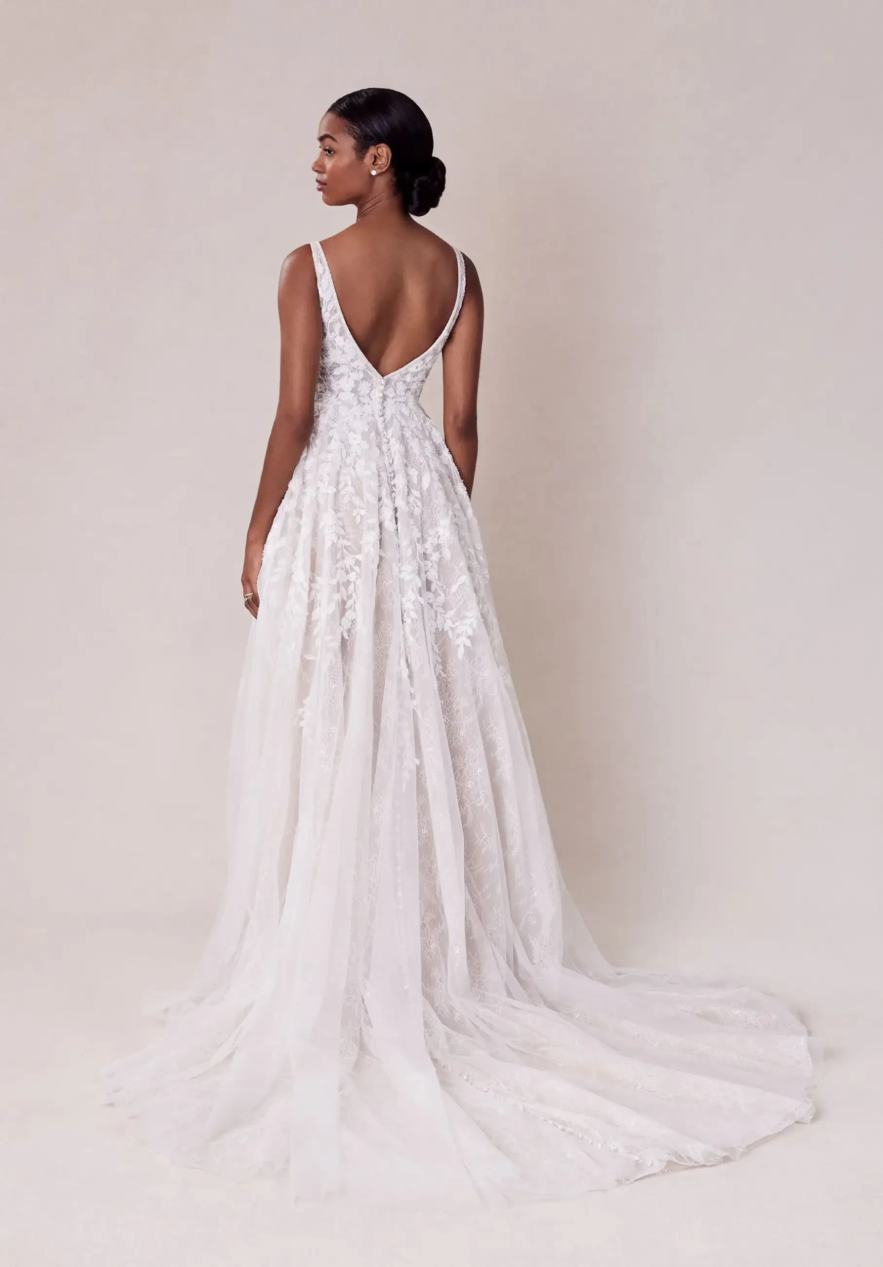 model is wearing a sleeveless a-line wedding dress with an open back by morilee