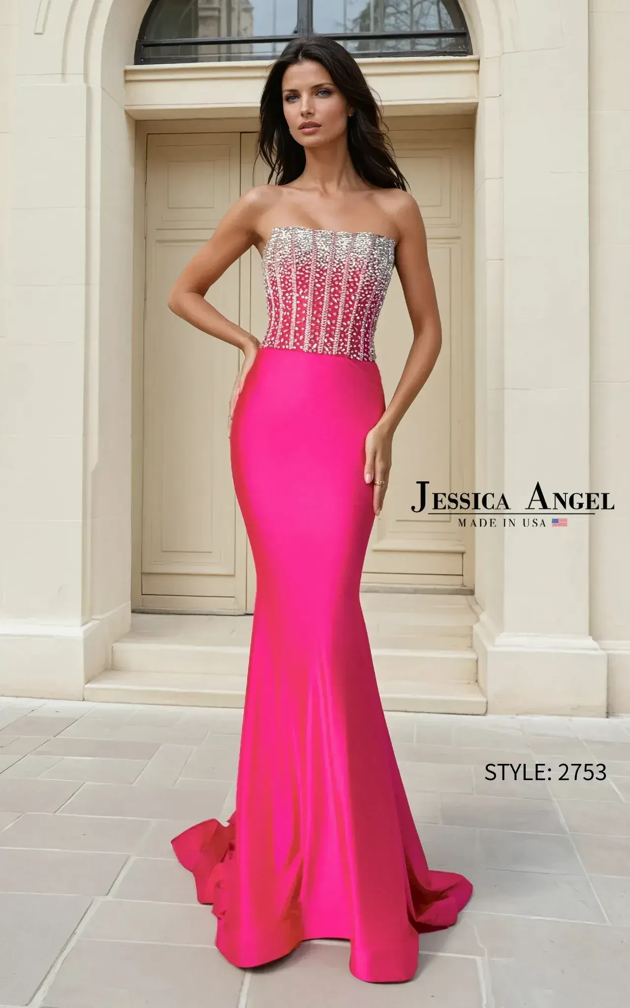 A woman stands confidently in a bright pink strapless gown with a sparkling silver bodice. She poses in front of elegant double doors, exuding sophistication.