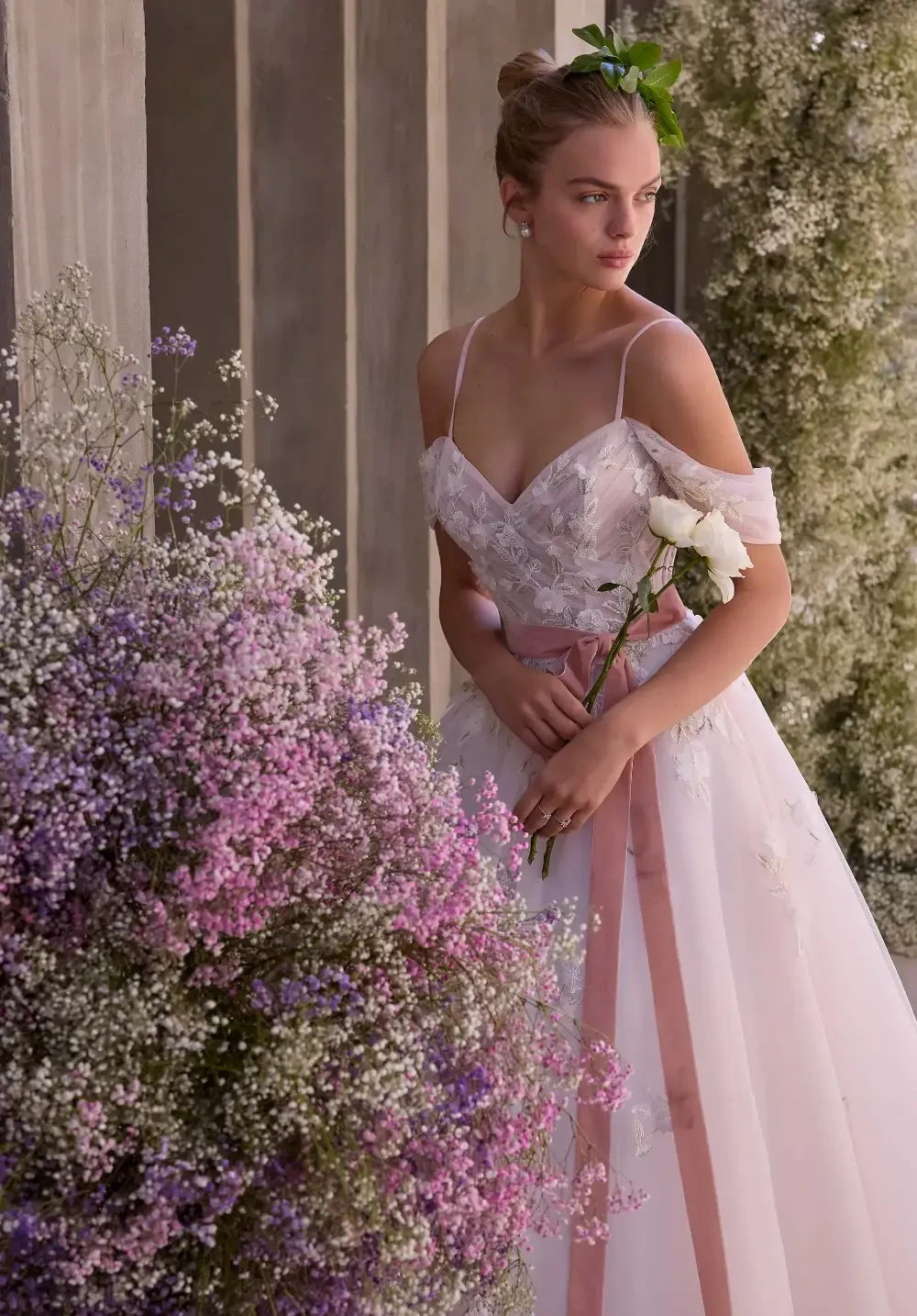 model is wearing an off the shoulder sweetheart wedding gown