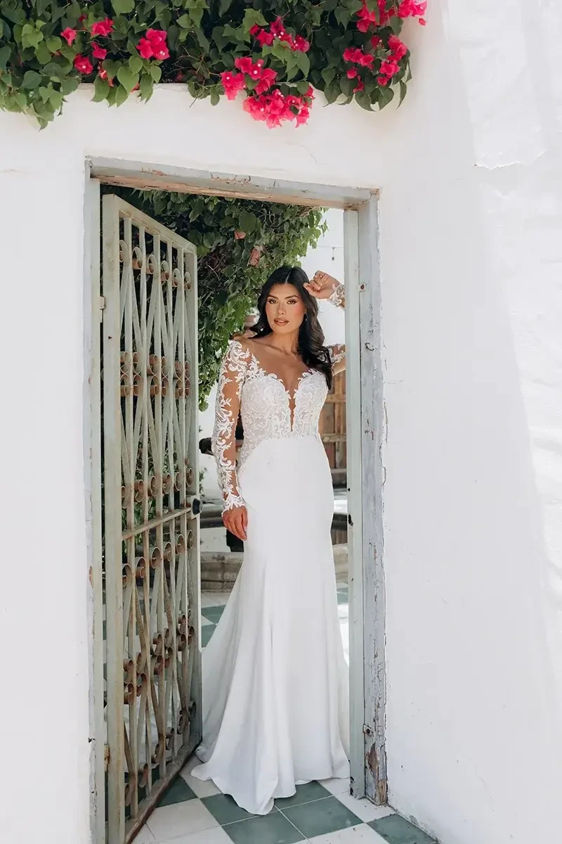 model is wearing a long sleeve fit and flare wedding dress