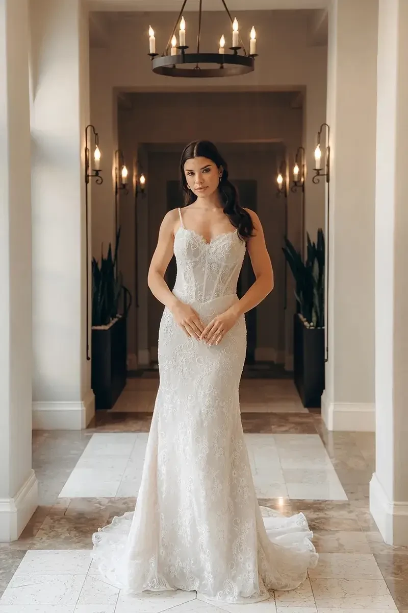 model is wearing a sleeveless lace sheath wedding dress