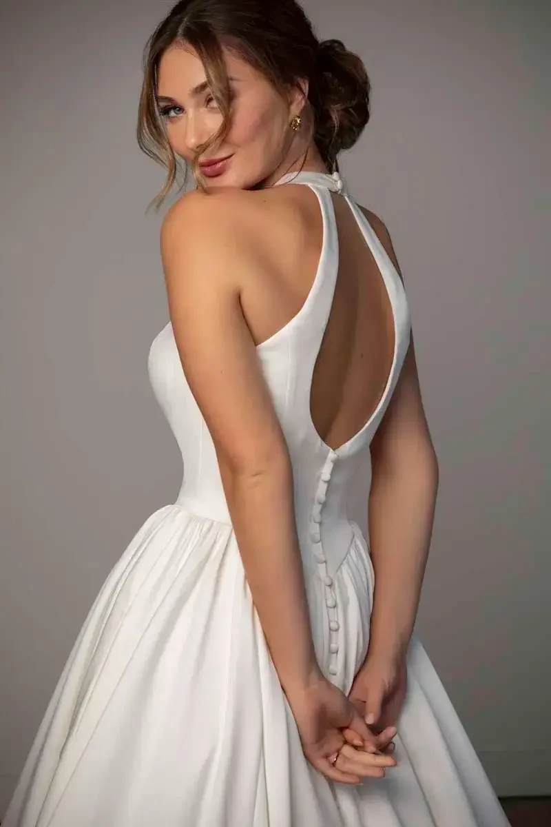 model is wearing a high neckline halter bridal gown
