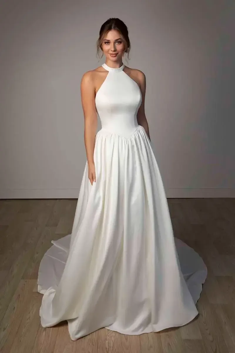 model is wearing a high neckline halter bridal gown