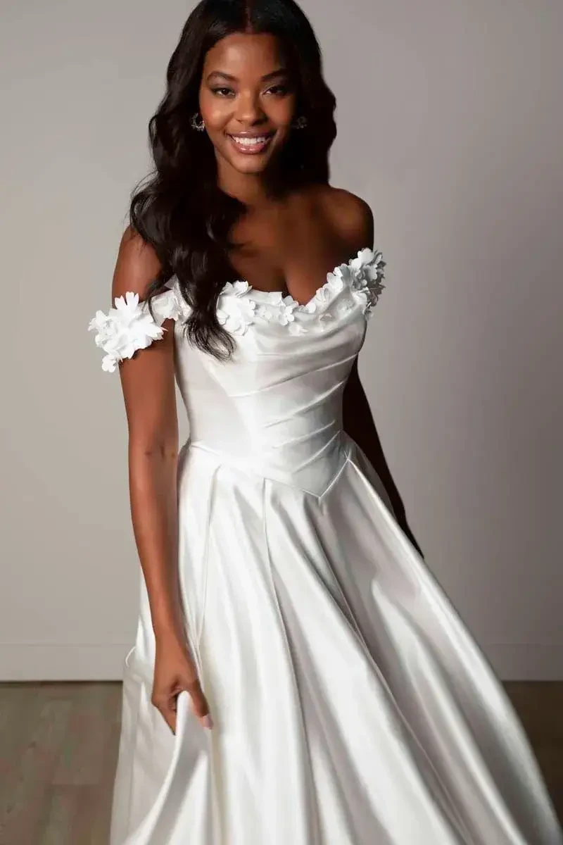 model is wearing an off the shoulder ball gown